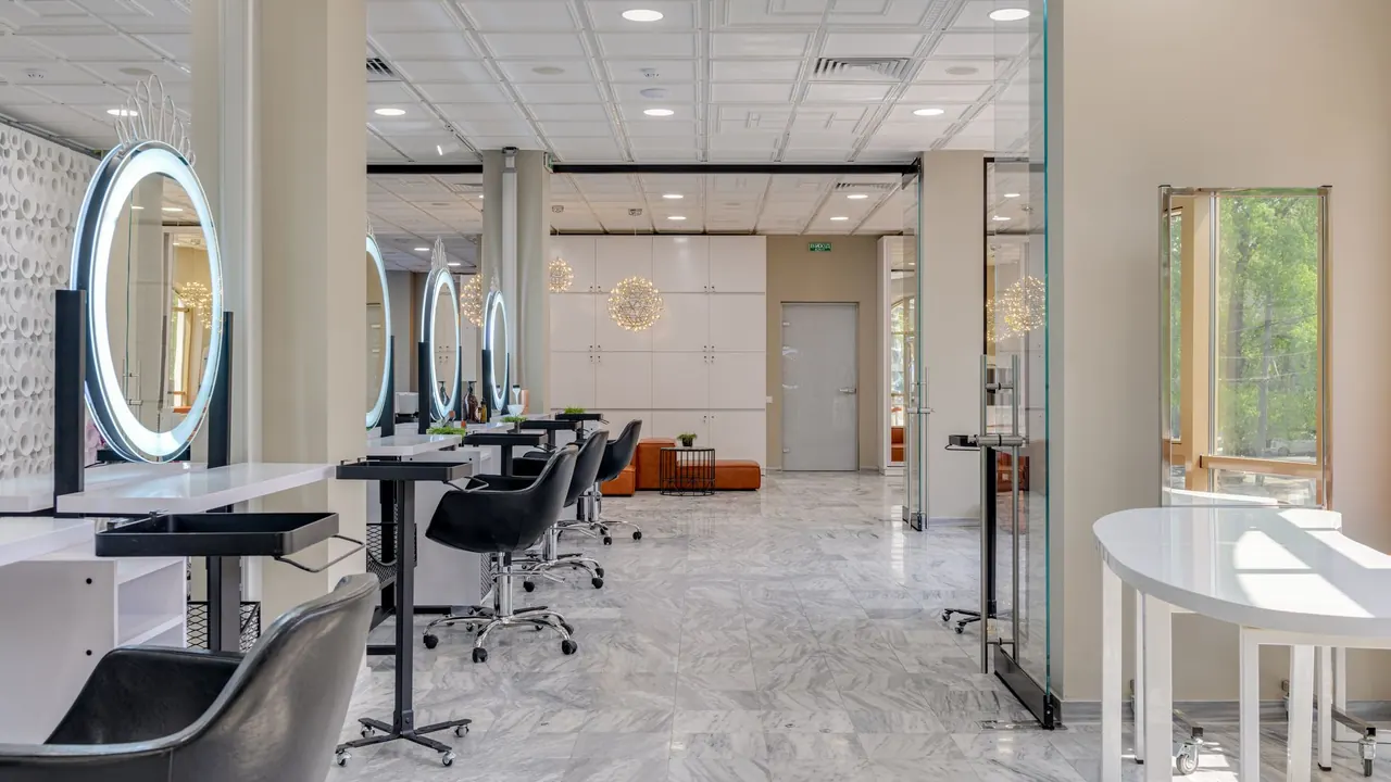 Aydınlık bir güzellik salonunda aynalar ve koltuklar
