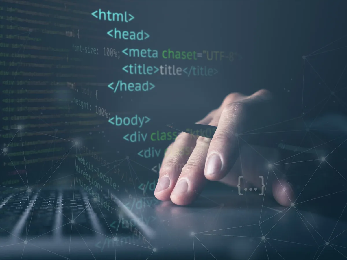 HTML başlık ve meta etiketlerinin göründüğü kod ekranı üzerinde klavyede çalışan el