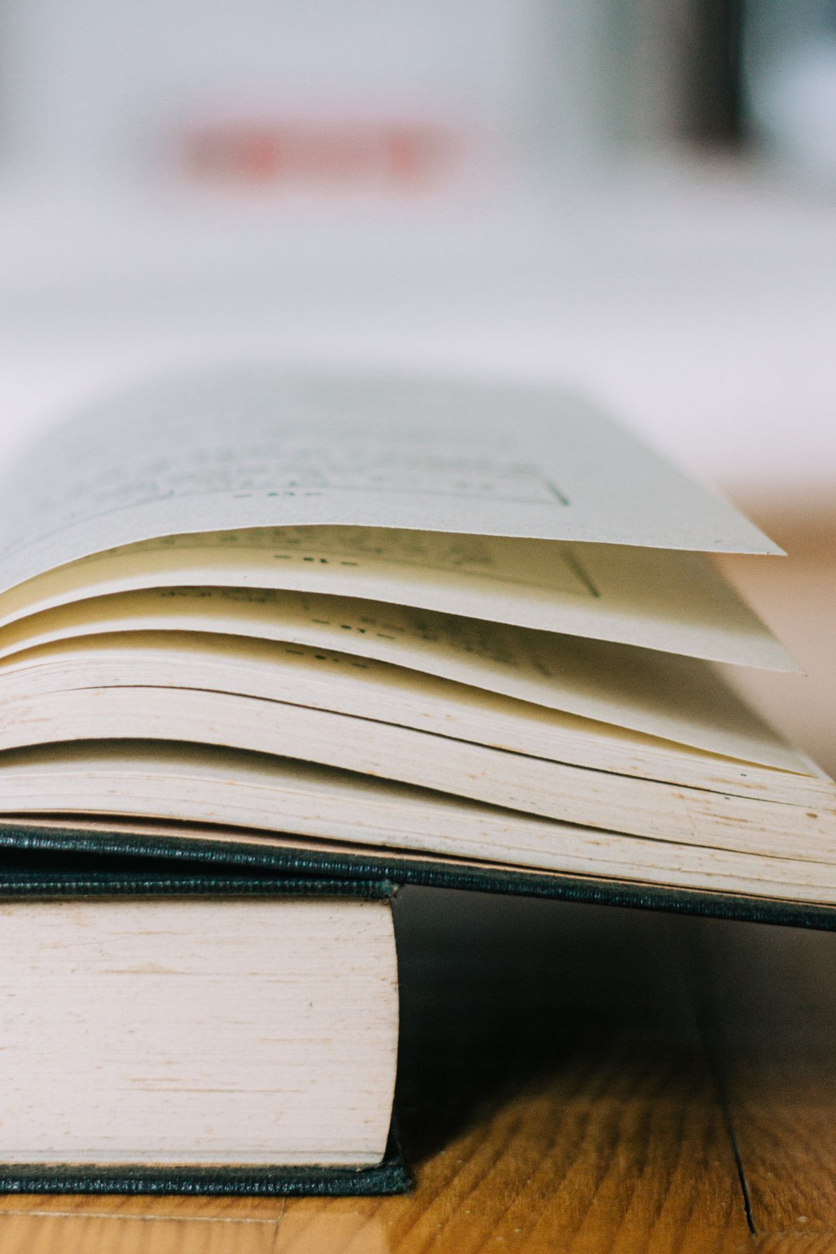Acik kitap sayfalari kapali kitabin ustunde, tek sayfa cok sayfali temsili